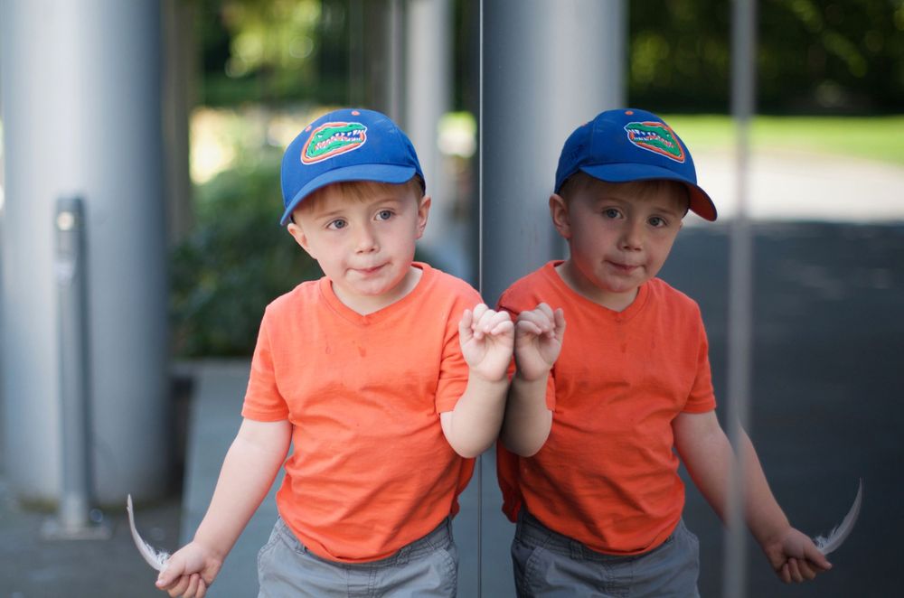 Kids wearing matching orange shirts playing together outdoors.