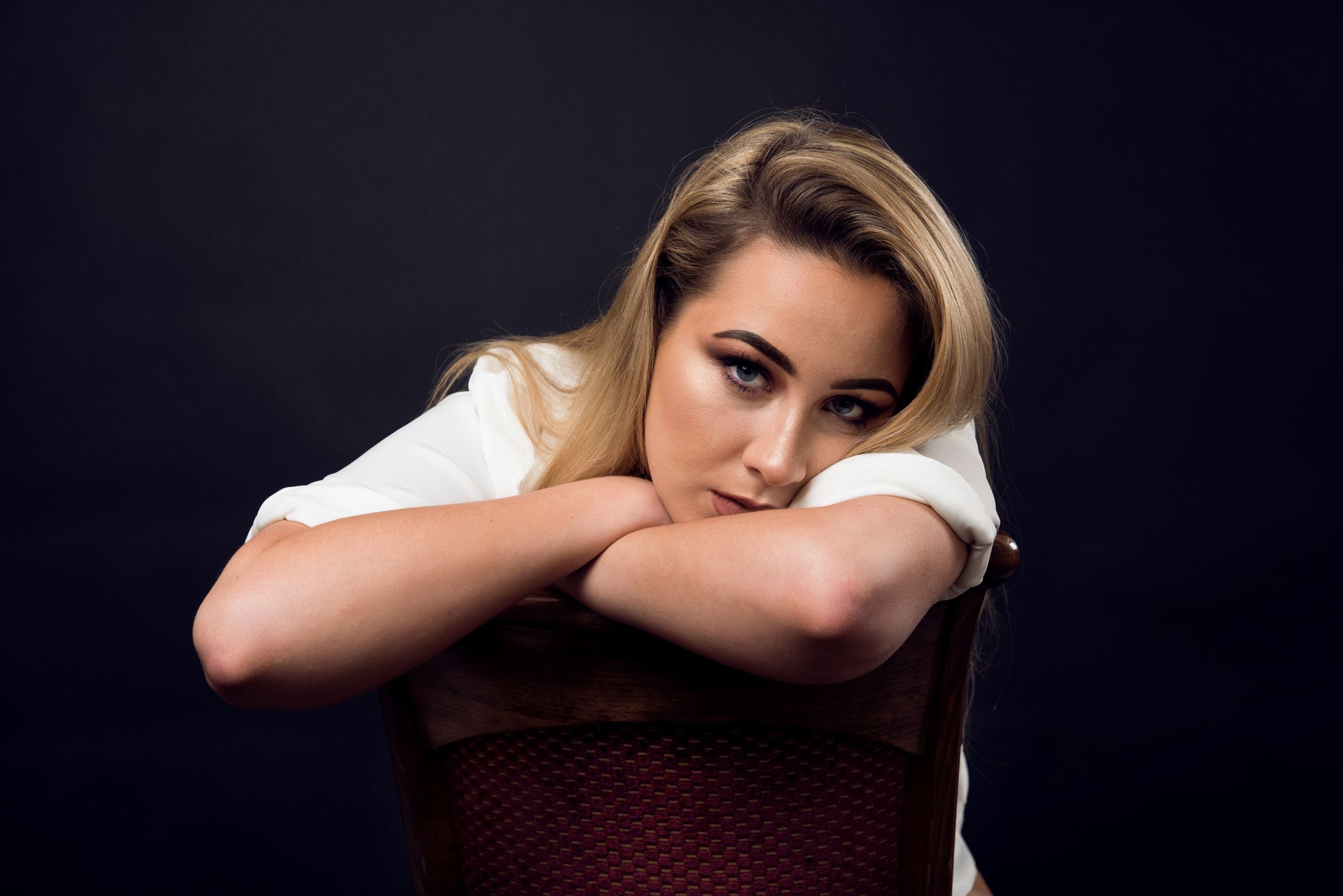 Dramatic portrait series against dark background with moody lighting.