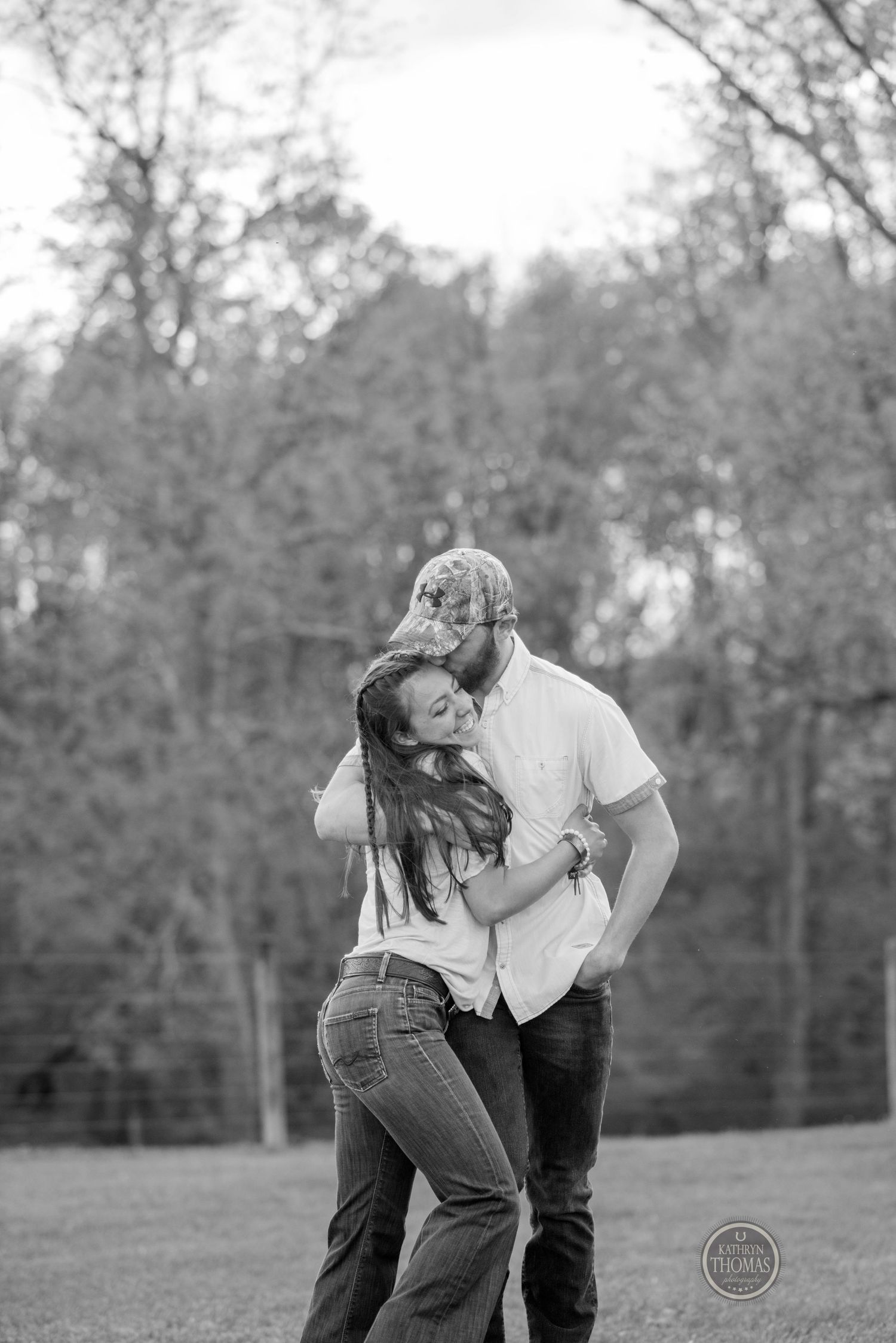 A couple embraces and laughs together in black and white on a spring evening.