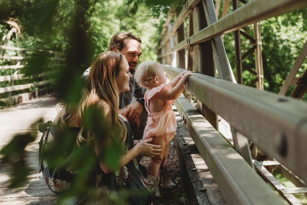parents and one year old on bridge