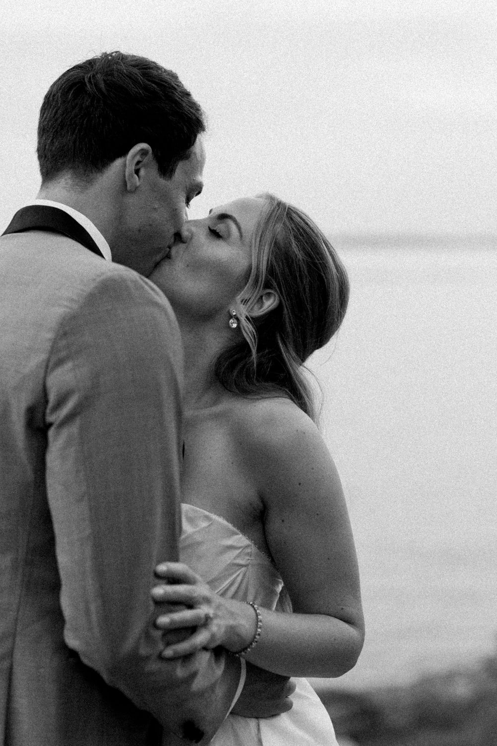 A romantic black and white photo sequence of a couple sharing a kiss outdoors.