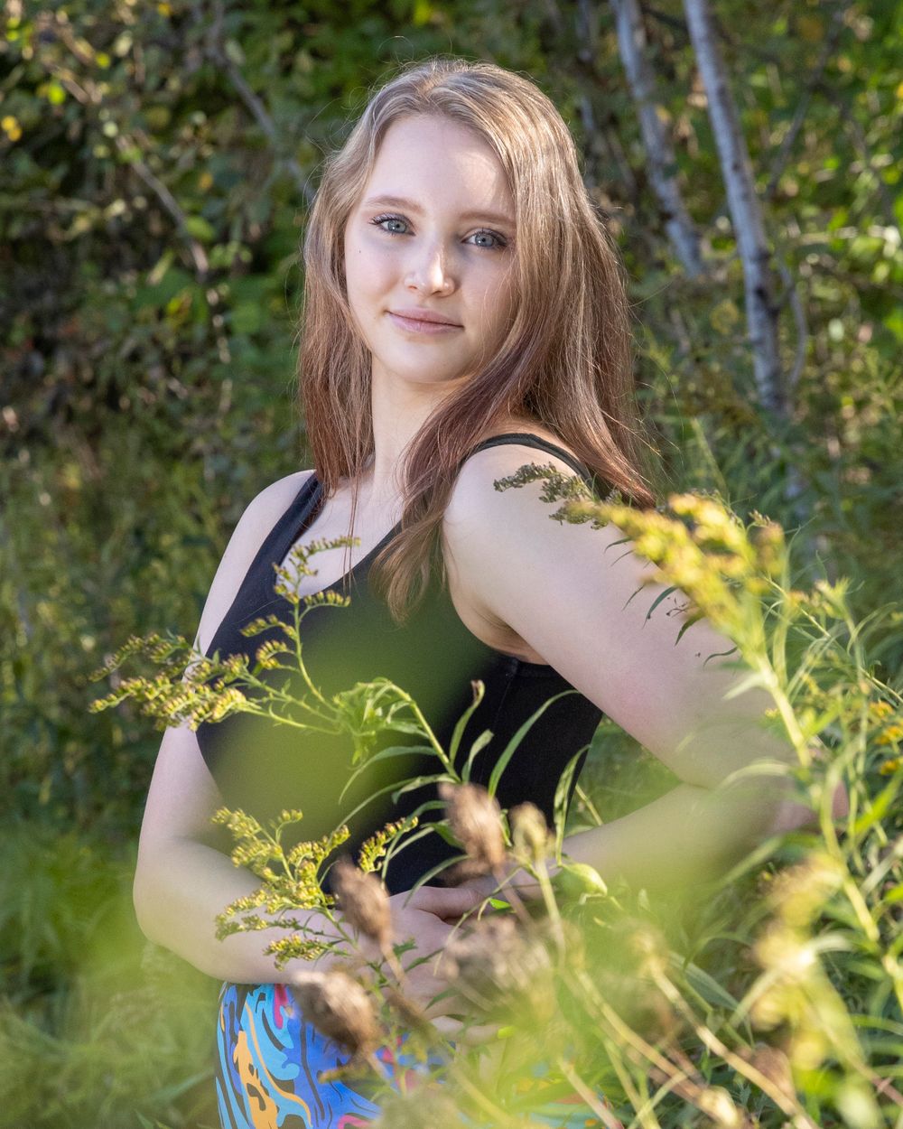 Nature portrait among golden wildflowers and green foliage.