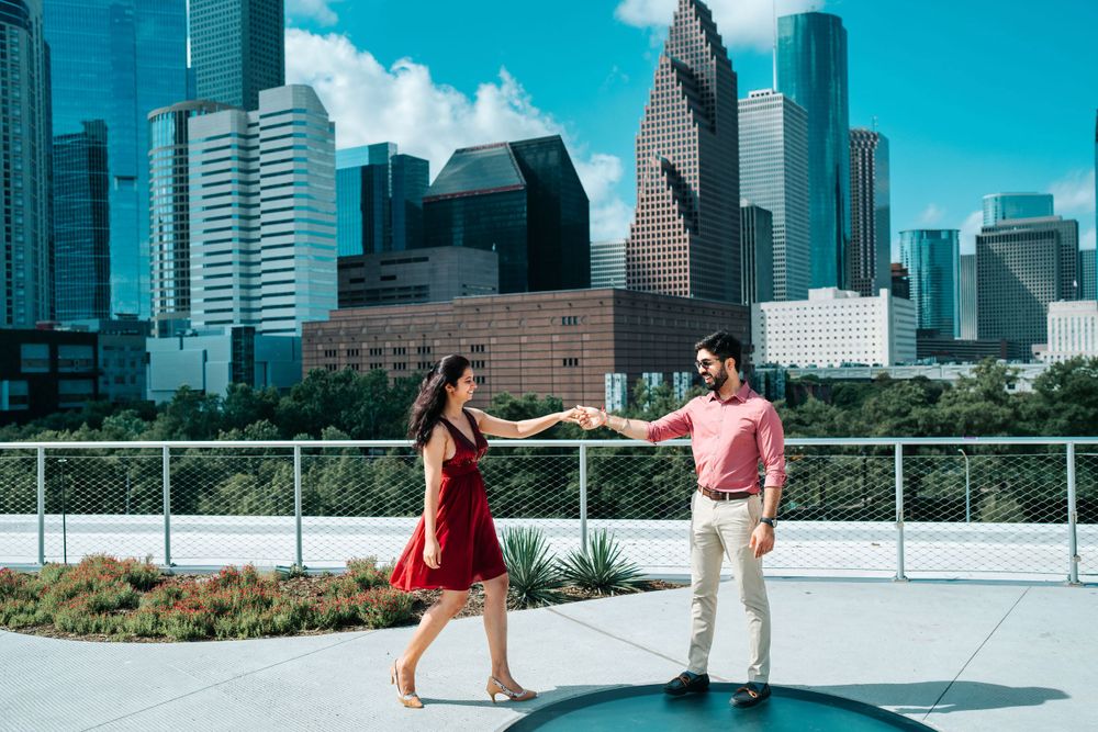A couple dances on a rooftop with the Houston skyline creating a dramatic urban backdrop.