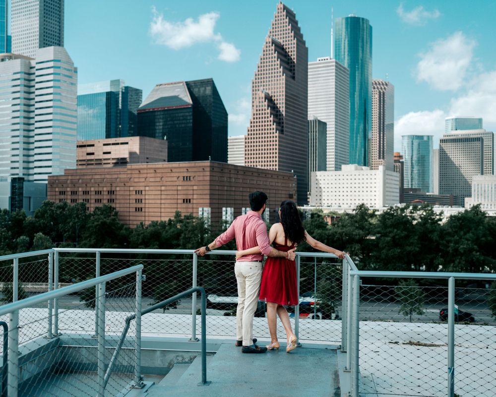 Couple admiring the Houston downtown skyline from an observation deck with decorative grasses.
