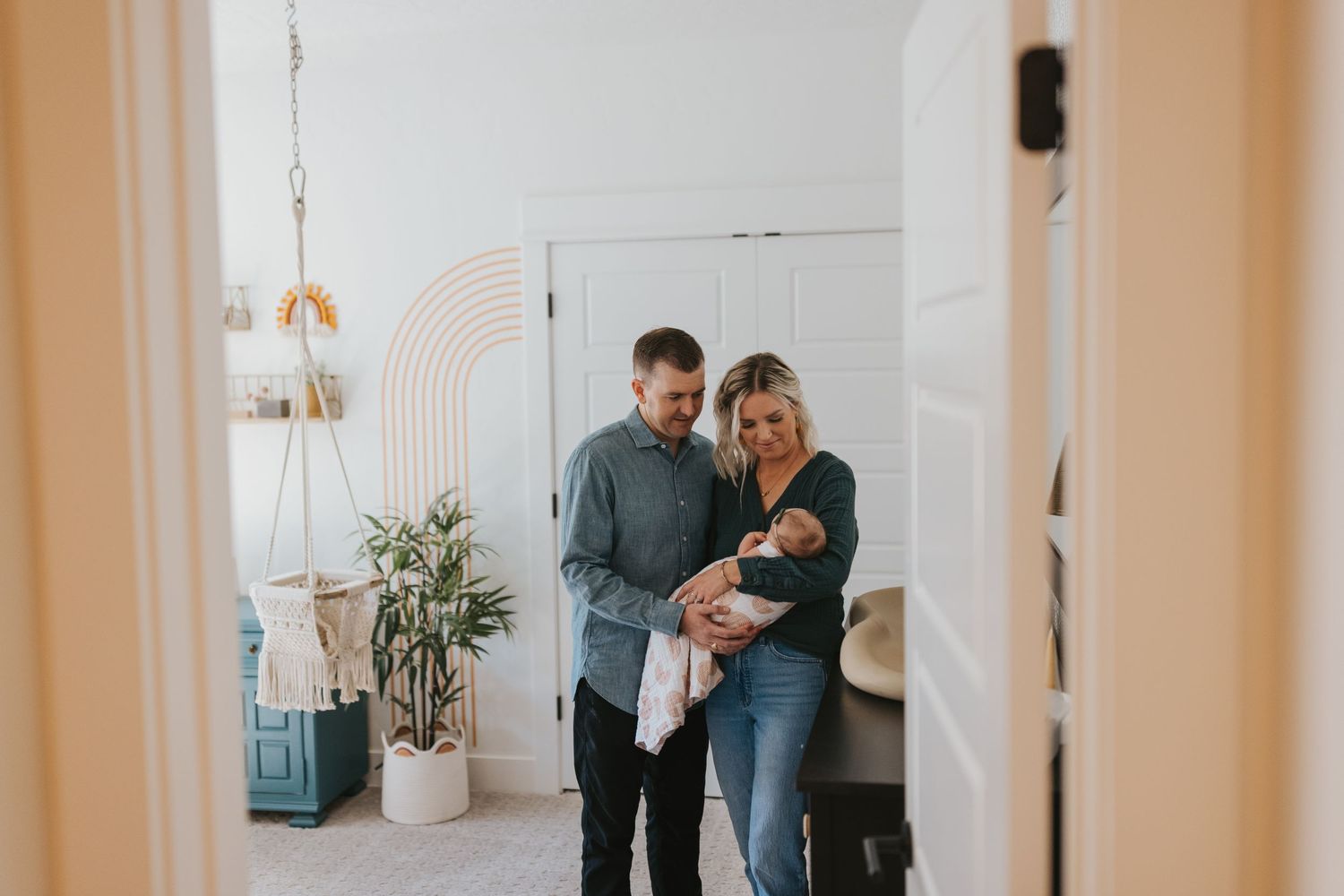 A family stands together in a bright, modern home interior with minimalist decor.