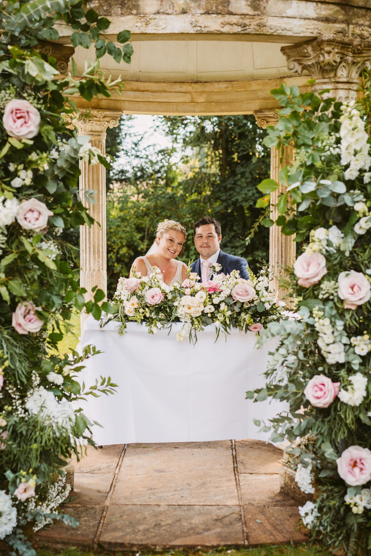 Outdoor ceremony at Ardington House under the Island Temple with floral arch display bride and groom sign register