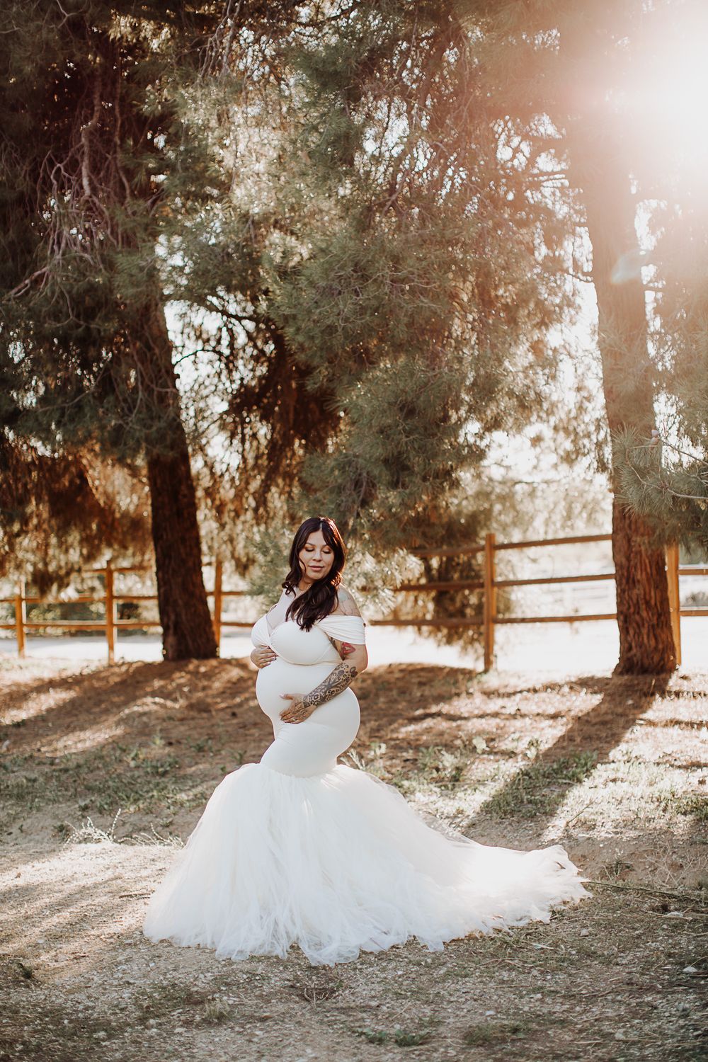 A flowing white wedding gown creates elegant movement against a natural wooded backdrop.