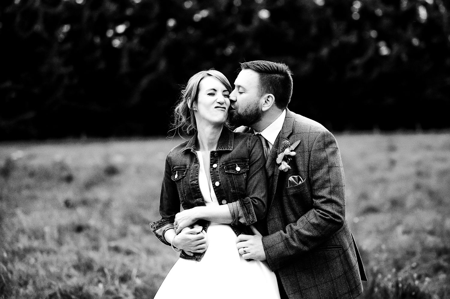 A black and white portrait of a couple sharing an intimate moment during their wedding.