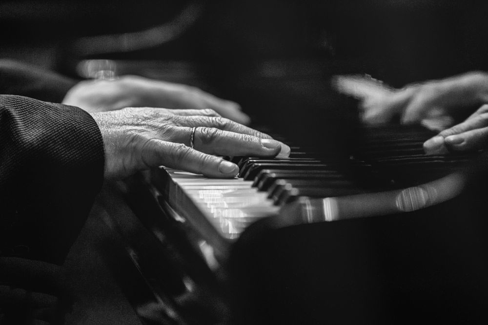 detail in Ewart wit van de handen van een pianist met de handen op de pianotoetsen