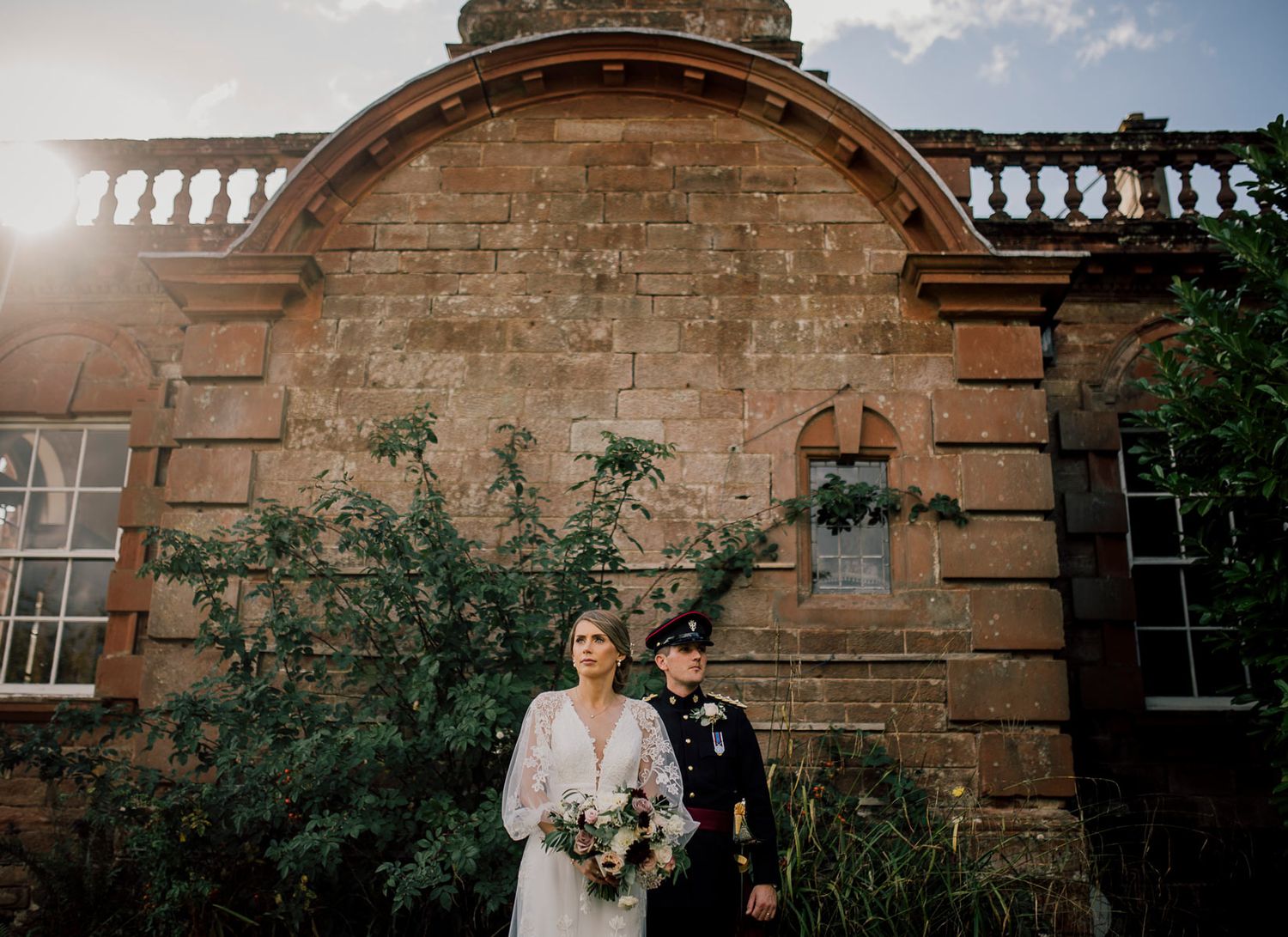 Wedding couple photographed in sequence against historic stone building with balustrade. Worcestershire Wedding photographer.
