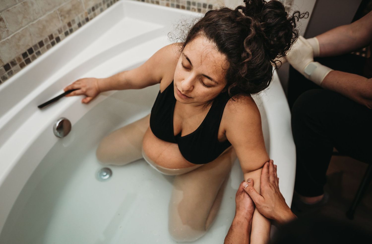 Home Birth mother laboring in tub during contraction. Laoch Midwifery, Neva Gerke, Lacey Birth Photographer