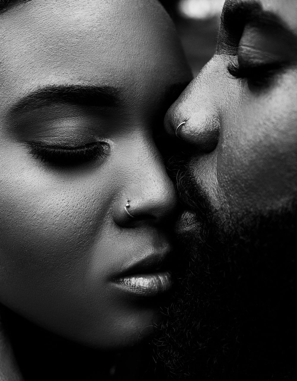 An intimate black and white close-up portrait of a couple.