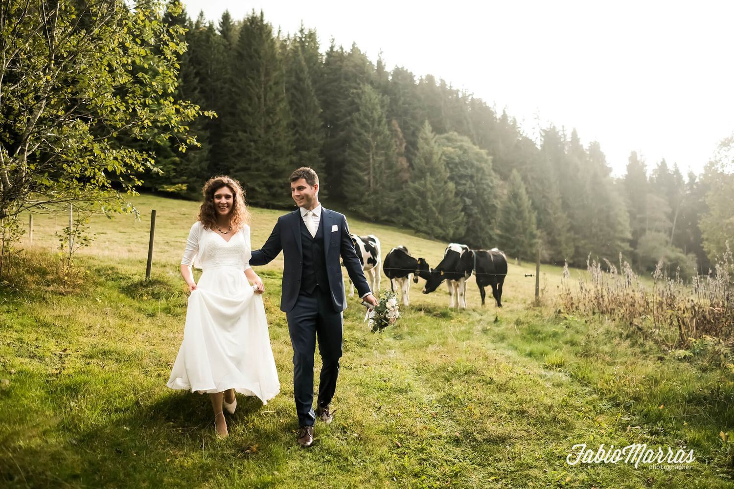 Brautpaar geht Hand in Hand über eine Wiese im Schwarzwald bei Titisee fotografiert von Fabio Marras
