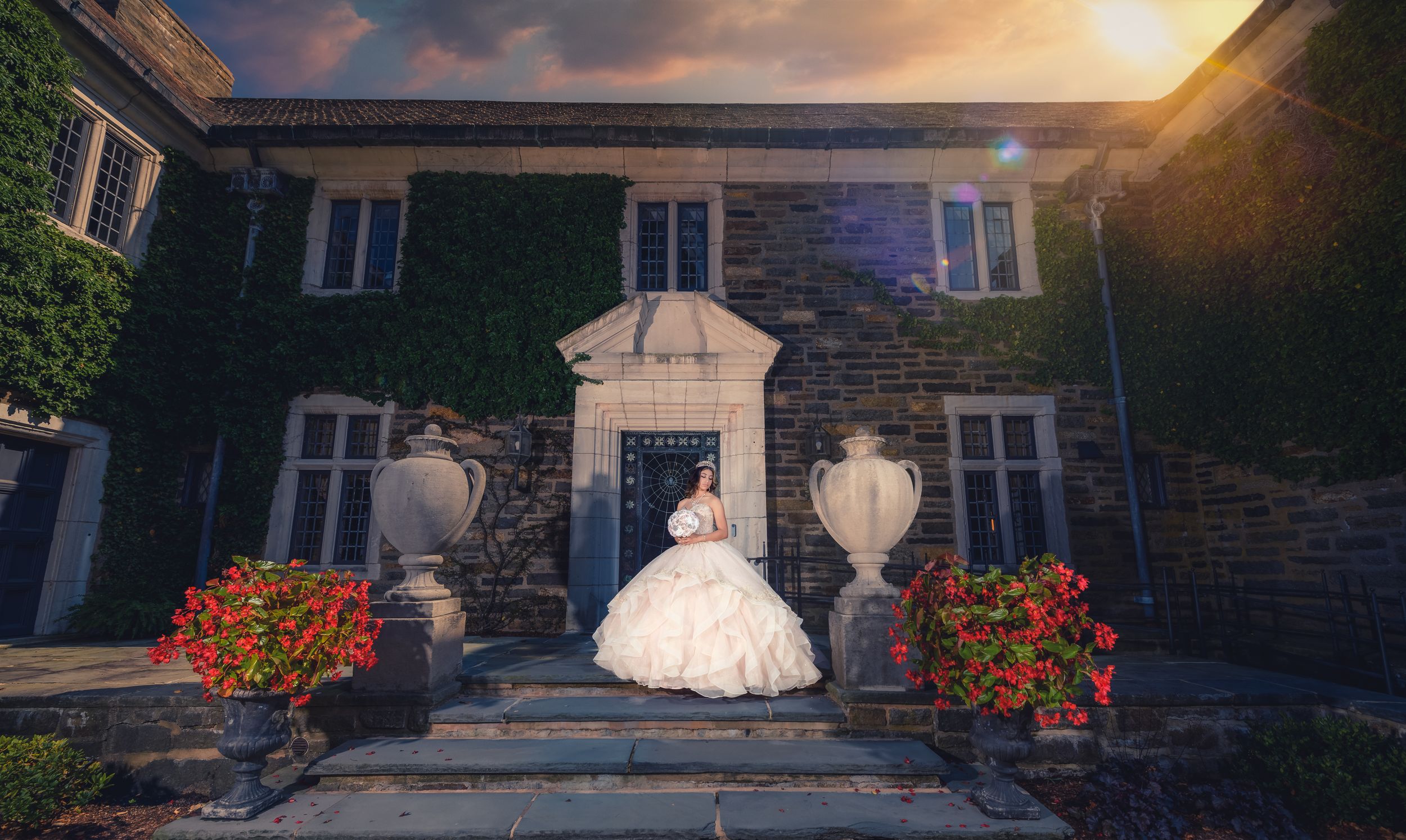 Pink ballgown dress photographed in front of a historic stone mansion at sunset.
