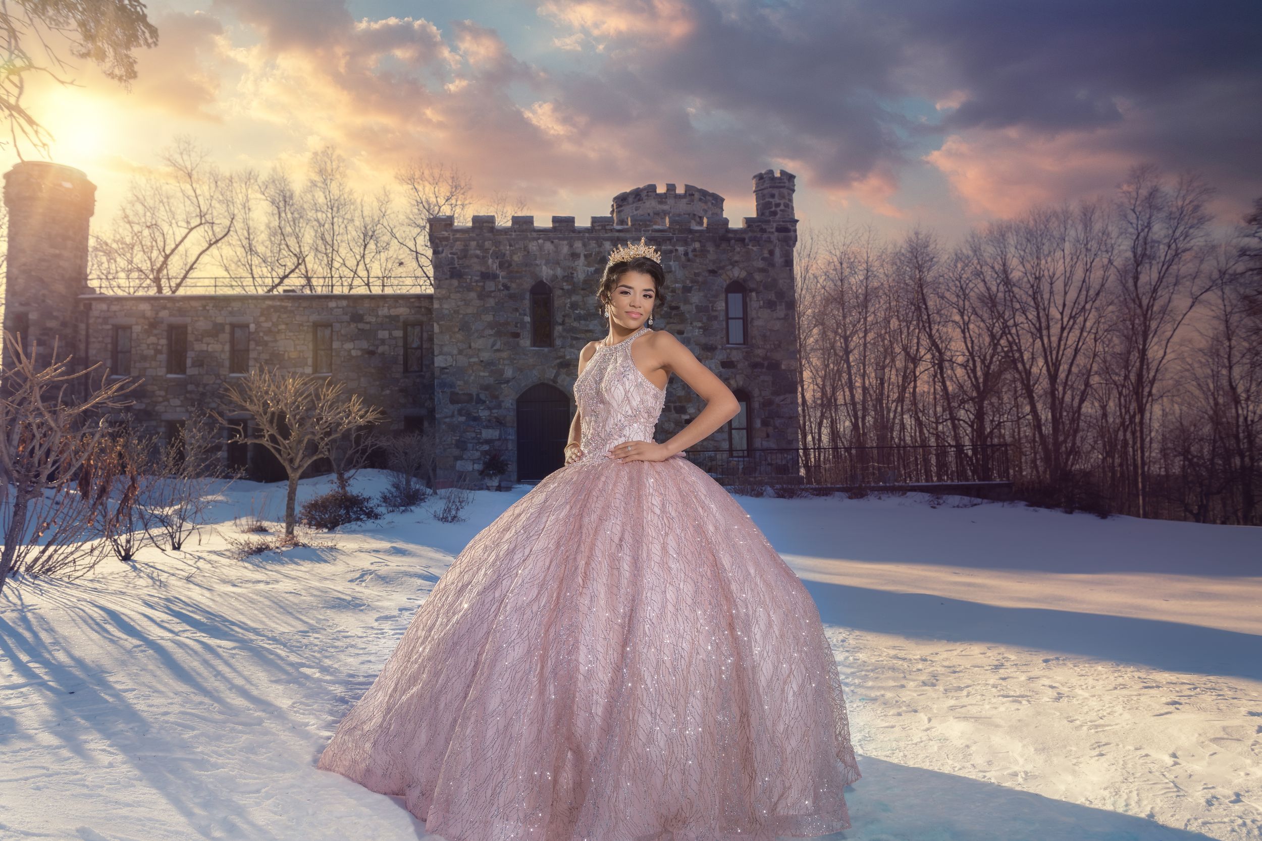 Pink princess gown captured in a snow-covered setting with castle architecture.