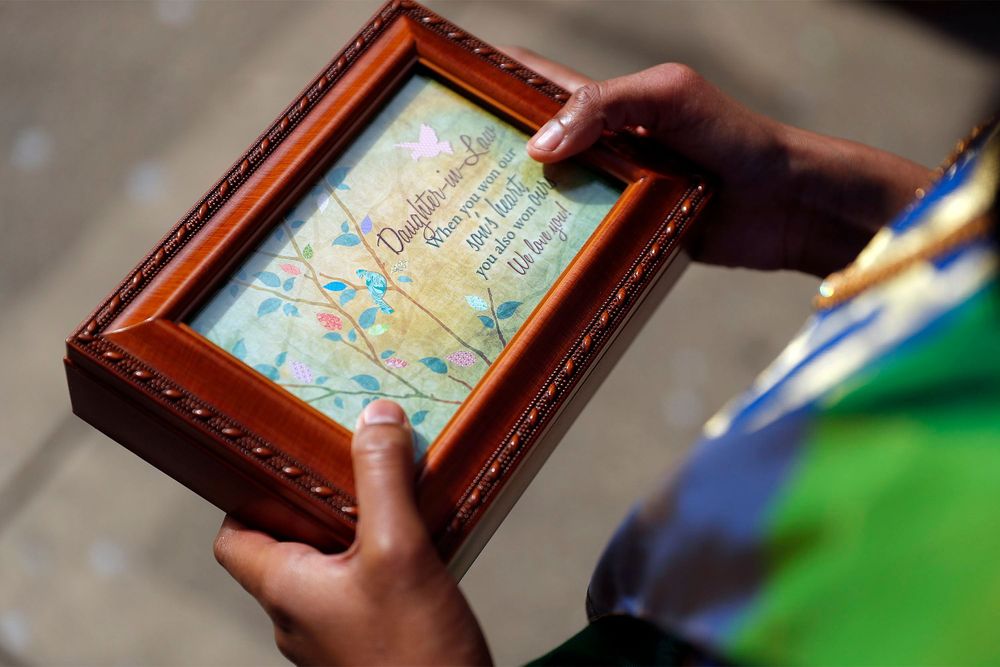 Hands hold ornate wooden framed photo by the Palace of Fine Arts.