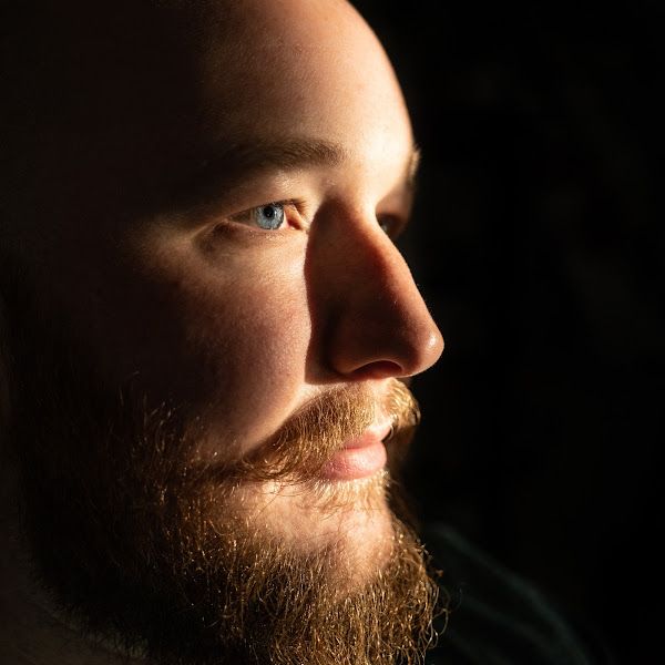 Close-up artistic profile shots of a bearded face in dramatic lighting.