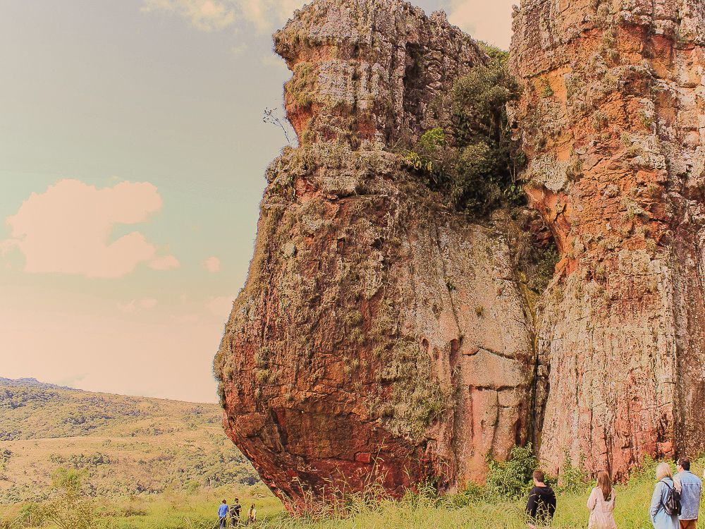 Massive sandstone rock formation rising above open landscape.