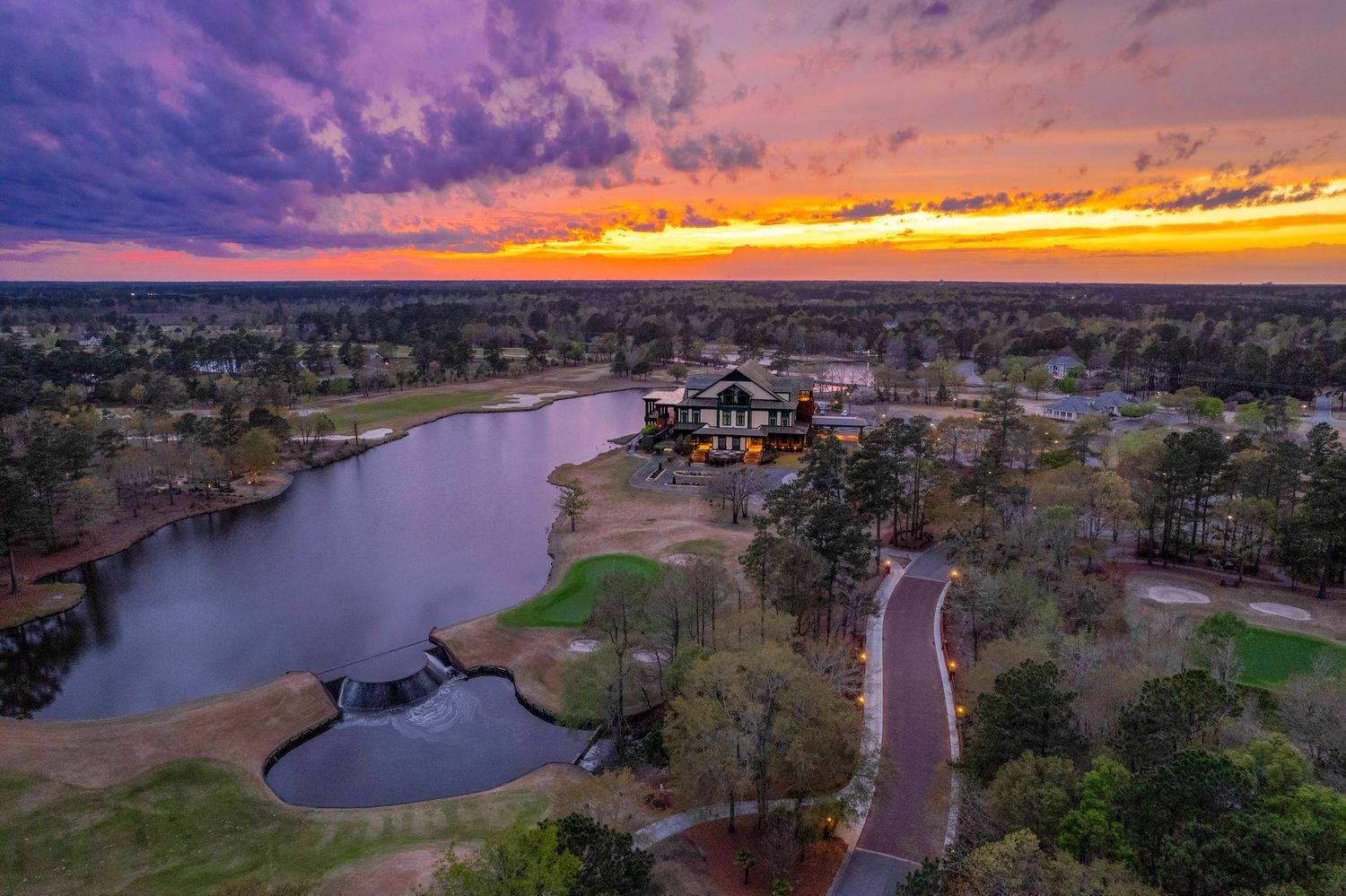 Panoramic aerial view of River Landing Country Club clubhouse at sunset.