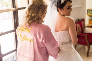 Getting ready scene with pink robe and white wedding dress.