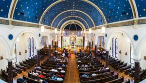 Cathedral wedding ceremony venue with starry blue ceiling and wooden pews.