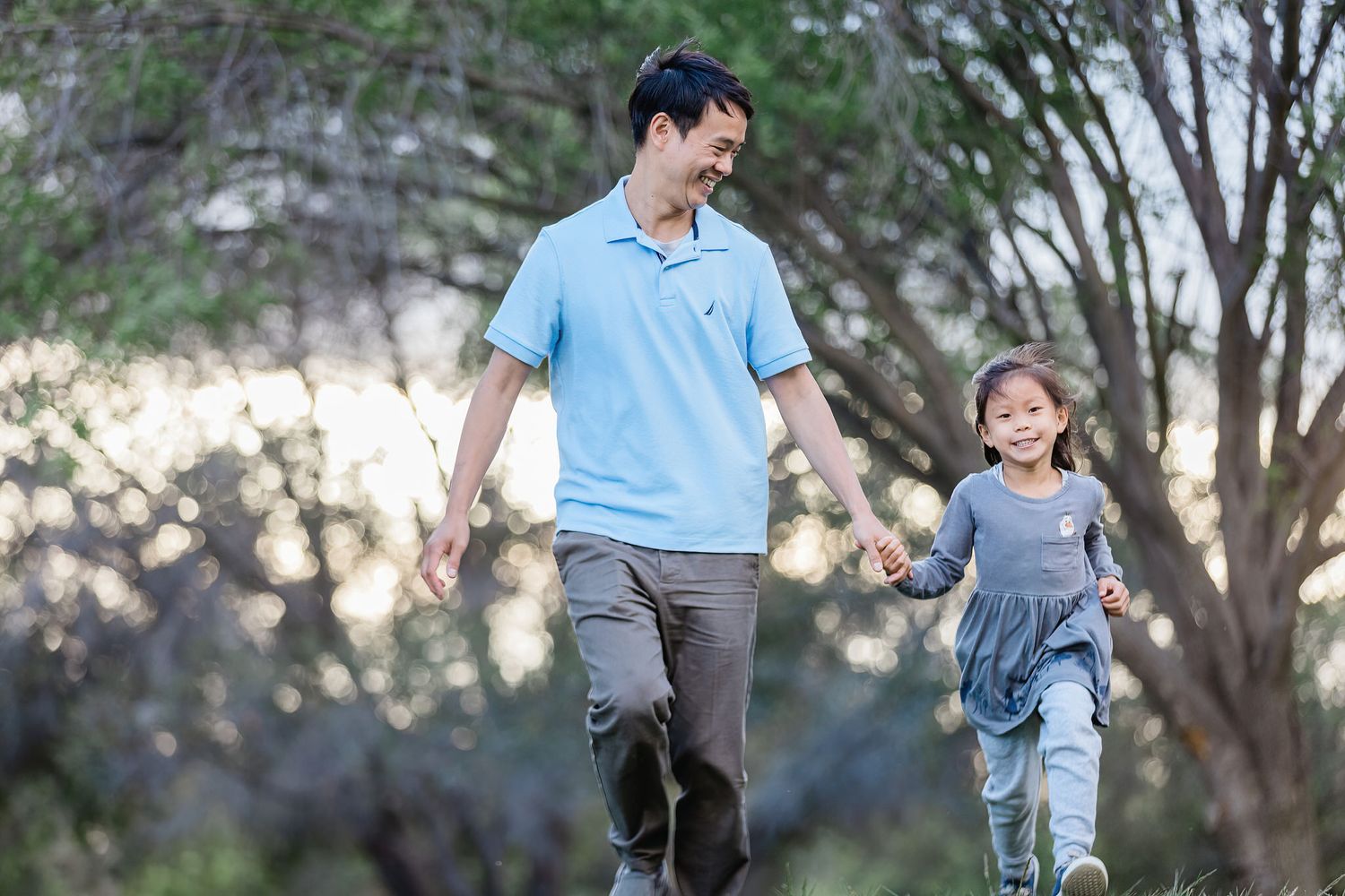Two people holding hands while walking together through a scenic outdoor setting.