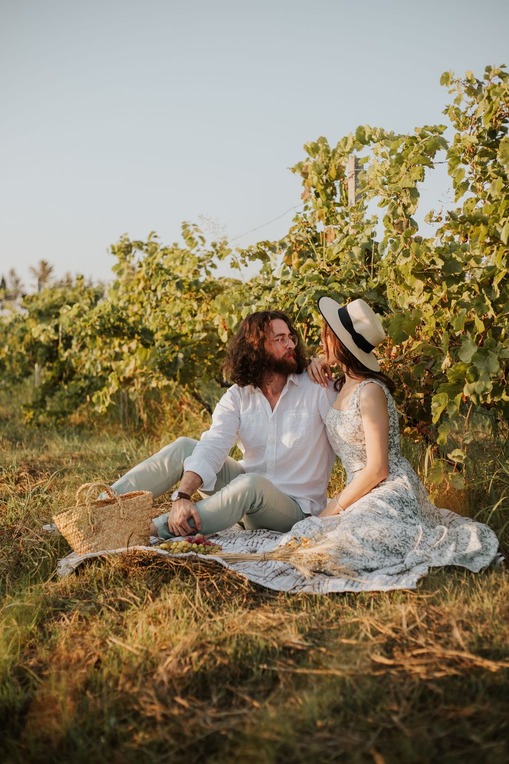 A romantic picnic scene set in a sun-drenched vineyard.