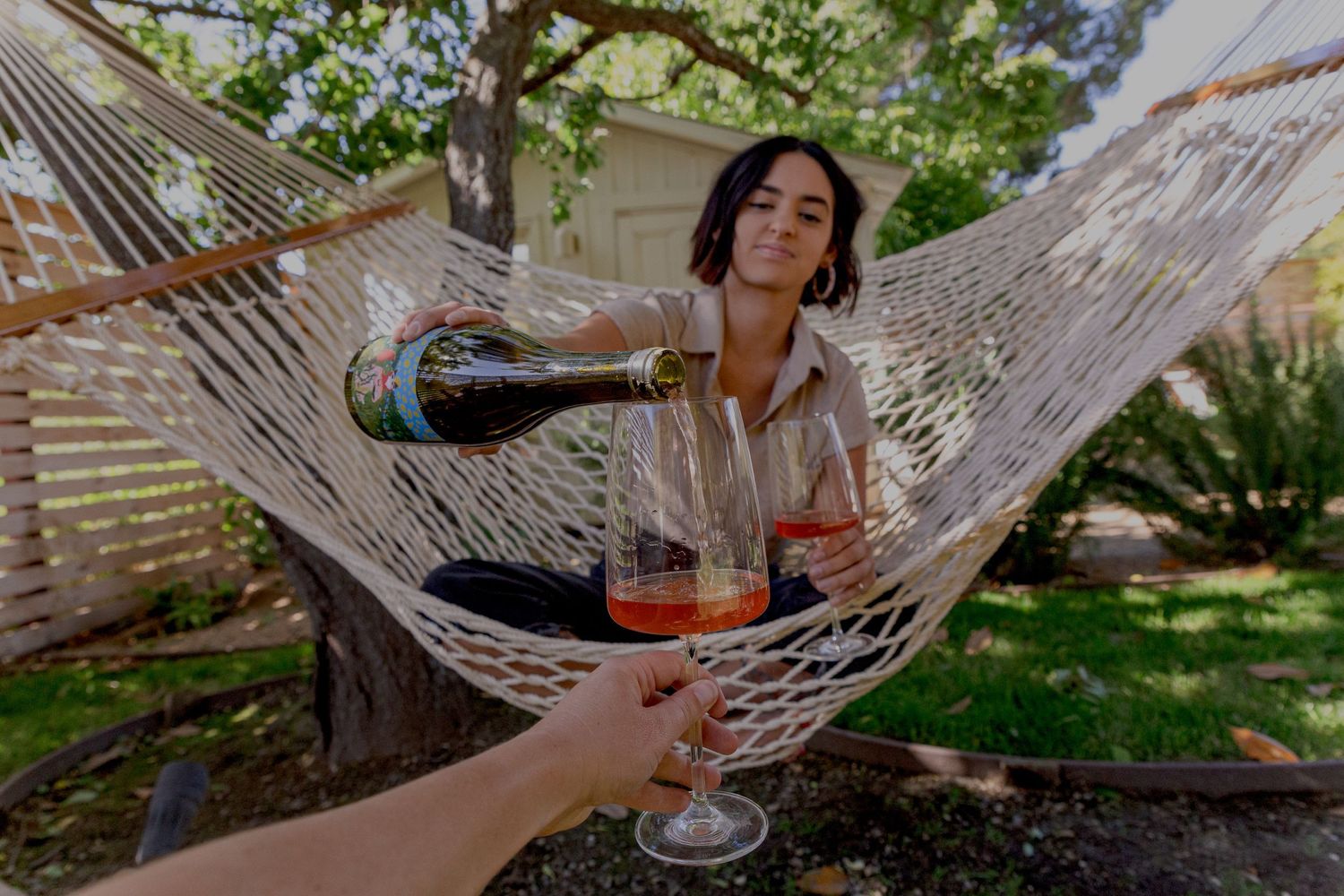 Nicole Crawford enjoying rosé on a hammock with a friend at Bodega Los Alamos