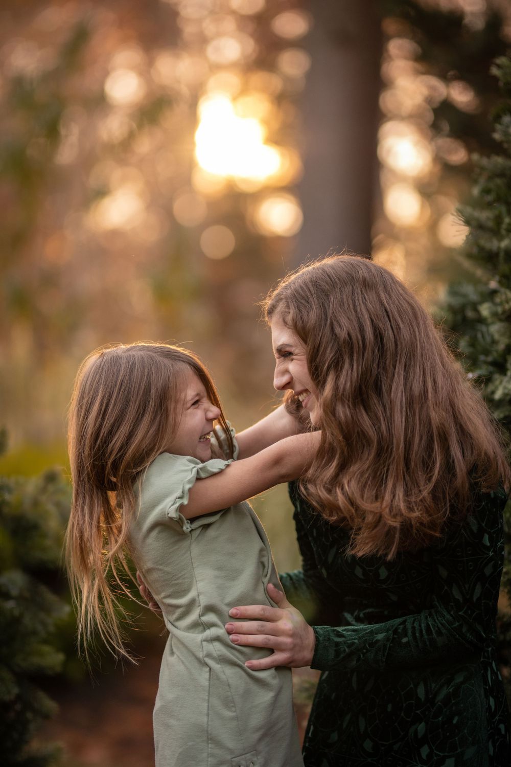 An intimate outdoor portrait showing playful affection against a sunset-lit background.