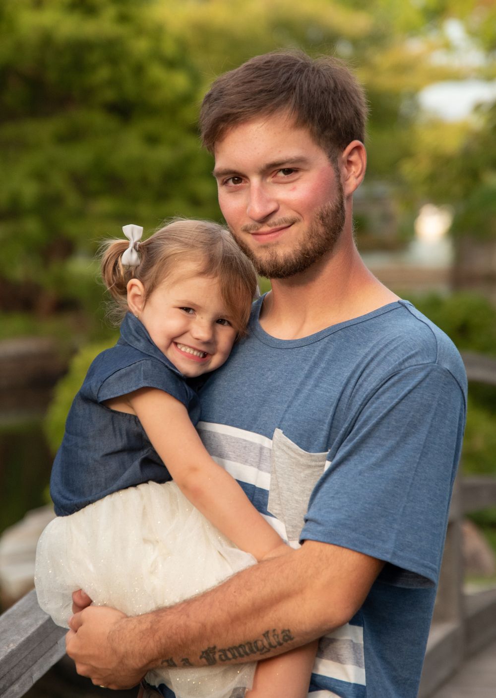 A sweet outdoor portrait showing affection and joy against a natural background.