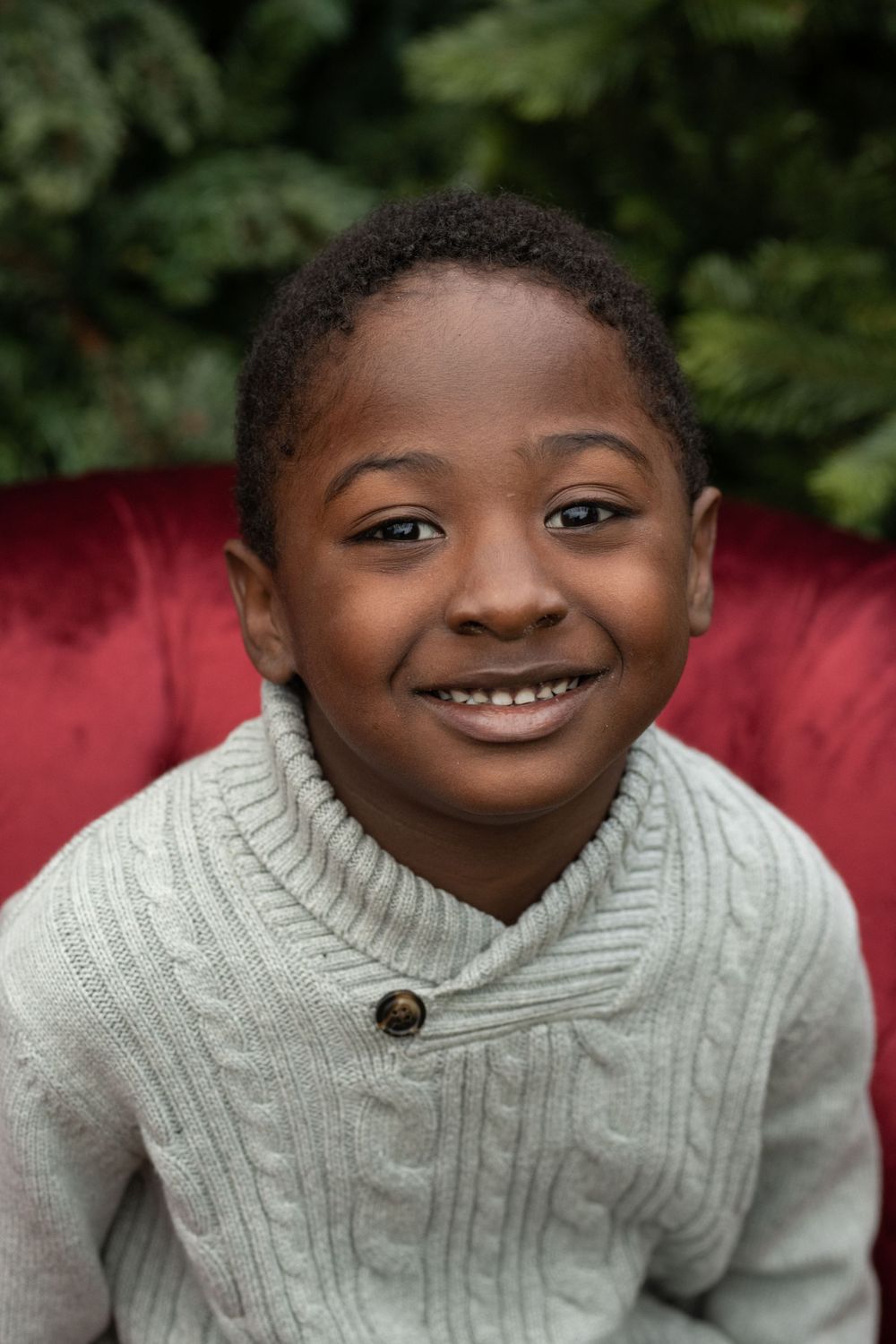 Person in a cozy cable knit sweater smiling warmly at the camera.