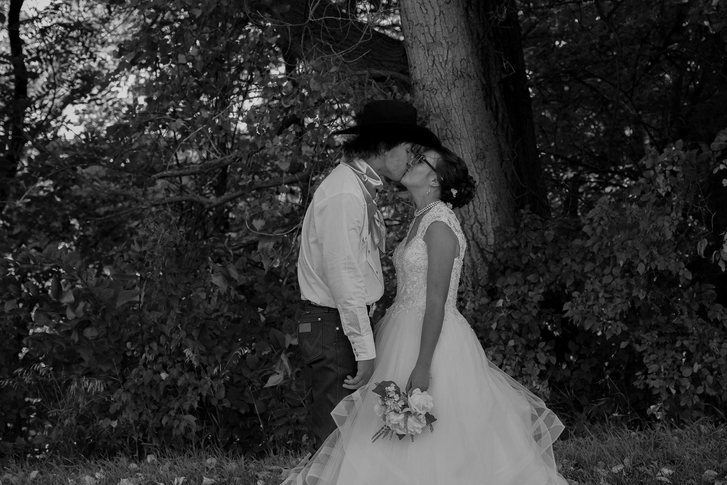 Black and white romantic portrait session in wooded area with natural lighting.