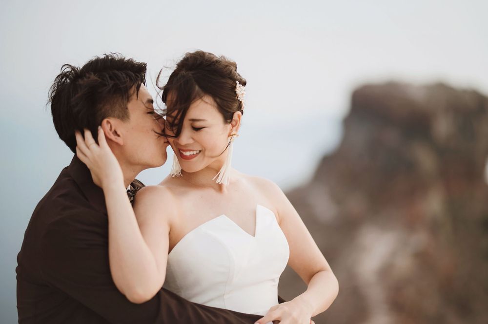 Emotional wedding portrait capturing intimate moment between couple against mountain scenery.