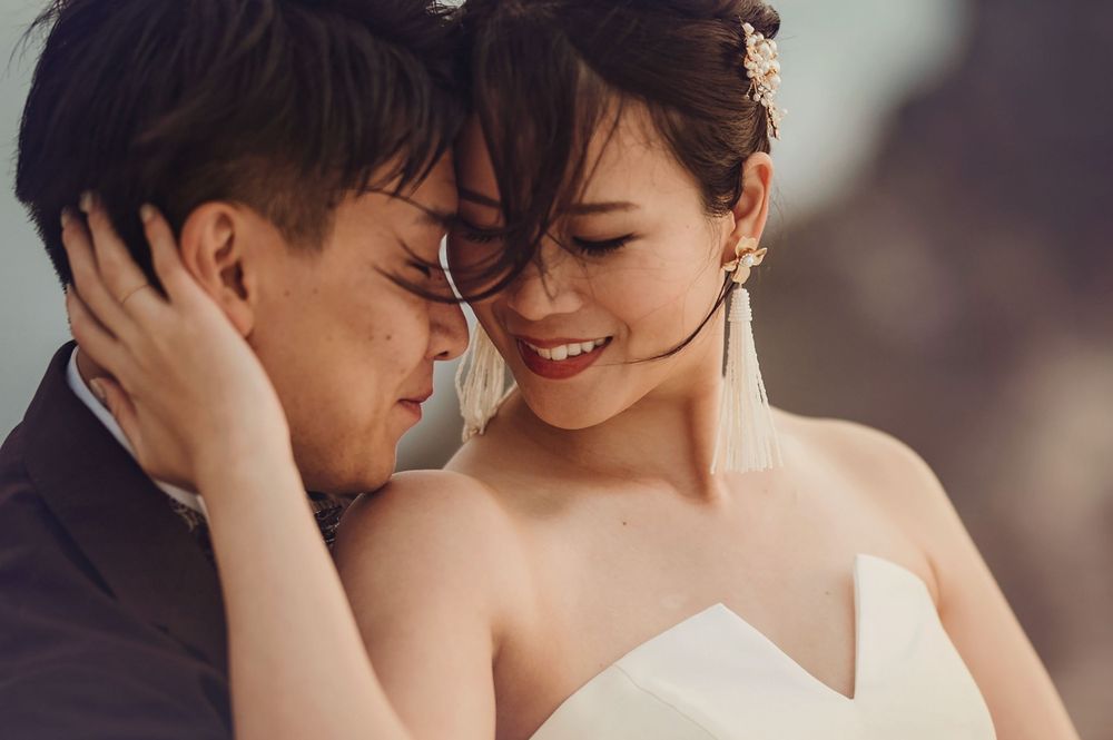 Tender moment between bride and groom sharing intimate embrace during outdoor wedding shoot.