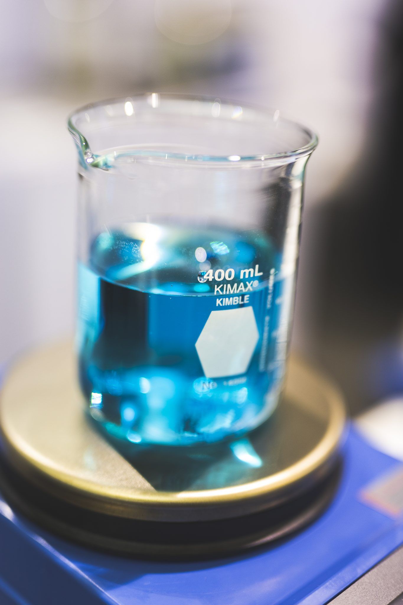 Laboratory beaker containing bright blue liquid marked at 100mL.