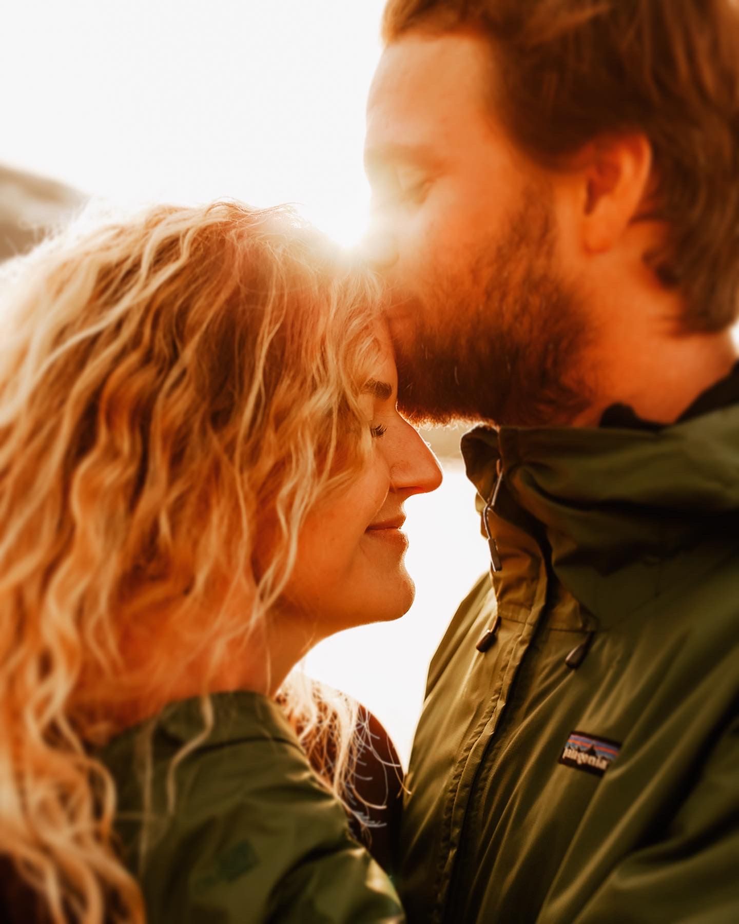 An intimate couple's portrait captured in warm sunset lighting.