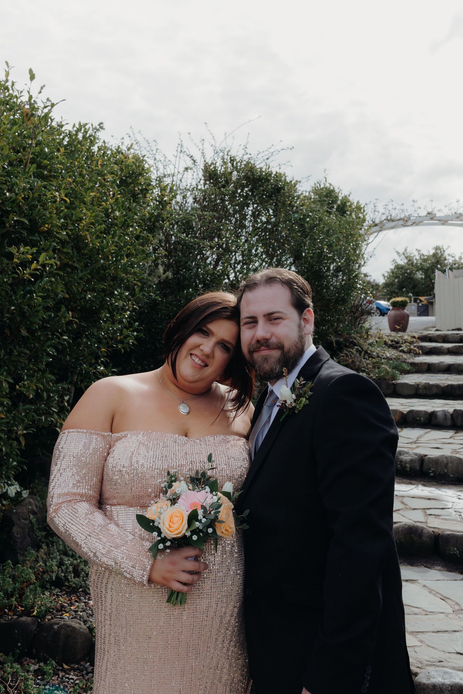 bride in sequin dress rests her head on her husbands shoulder