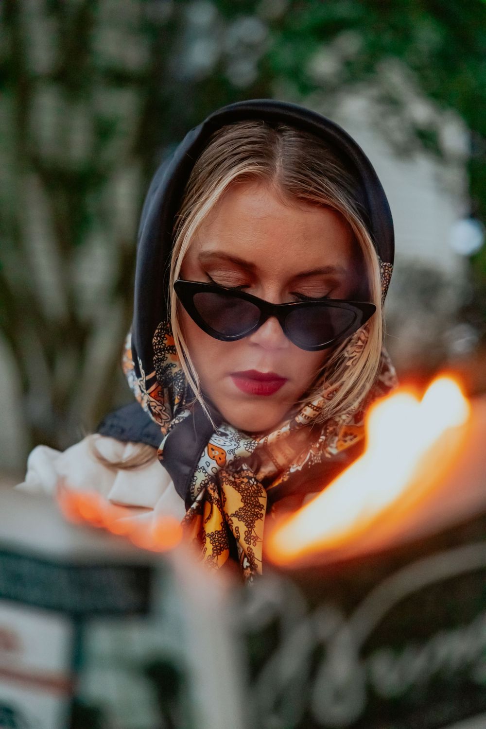 Dramatic close-up portrait with sunglasses and fire reflections in mirror fragments.