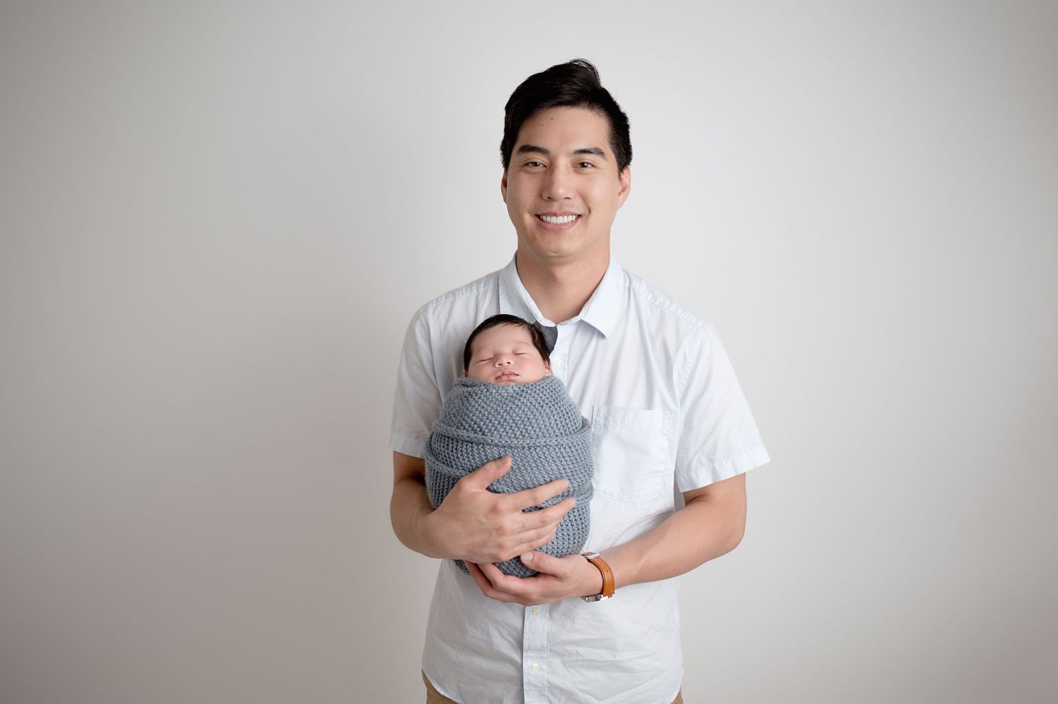 Studio portrait session with family in white and gray outfits.