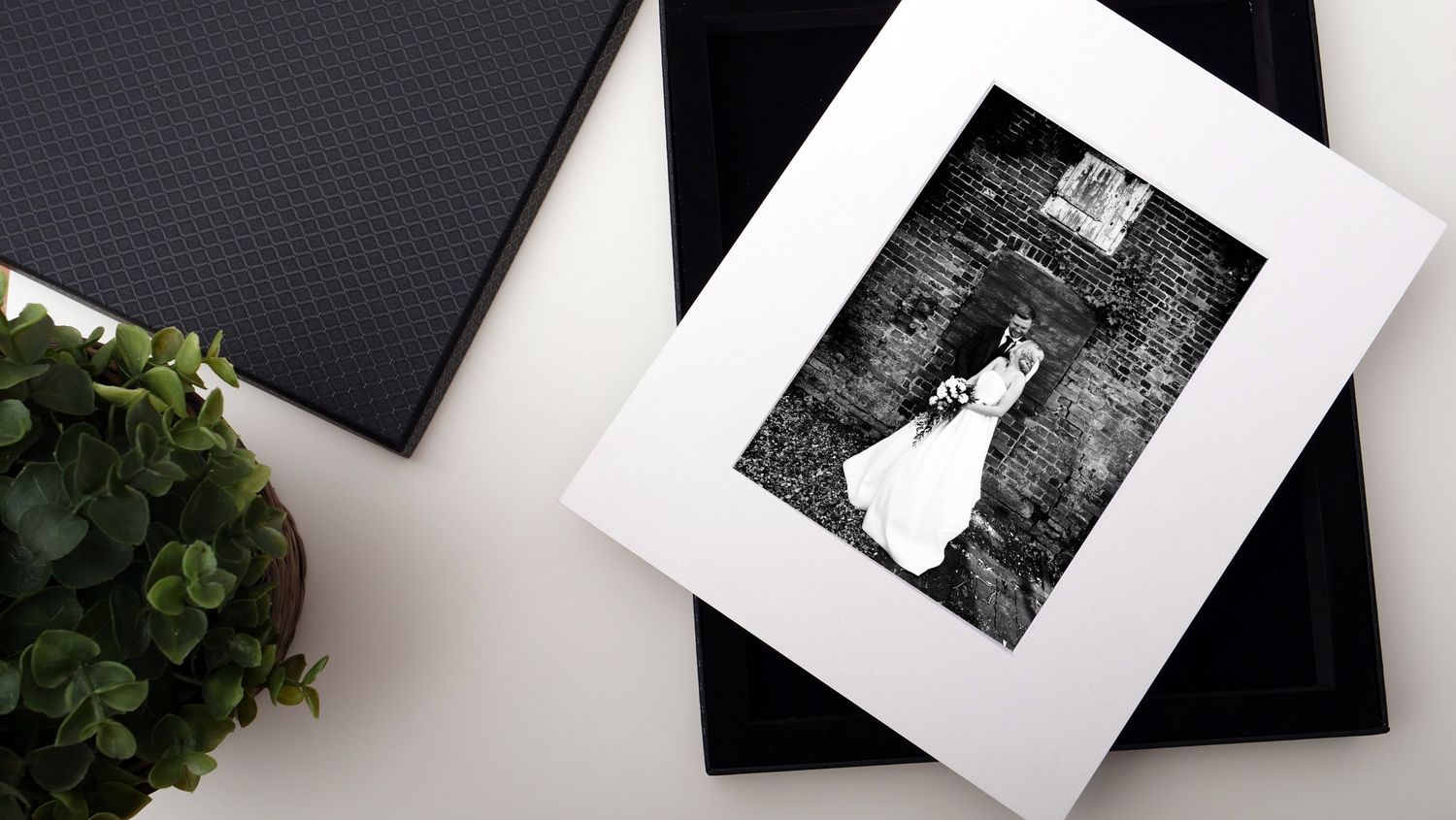 Wedding photo in black and white matted frame displayed with decorative elements.