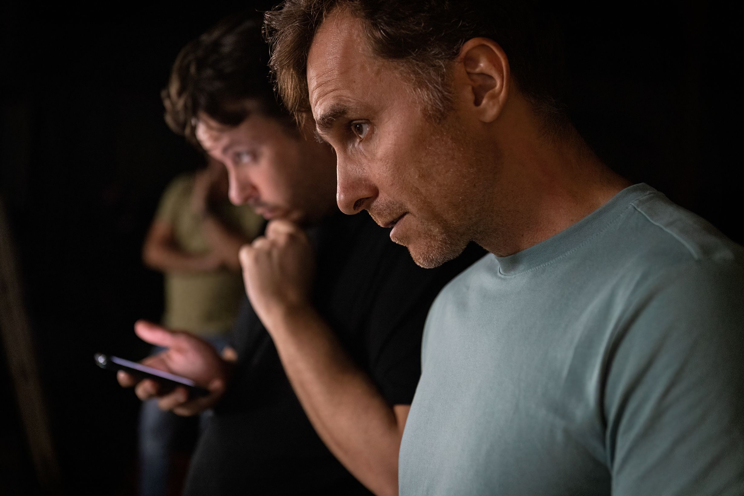A film director looks at a scene. Beside him is the 1st assistant director looking at a mobile phone.