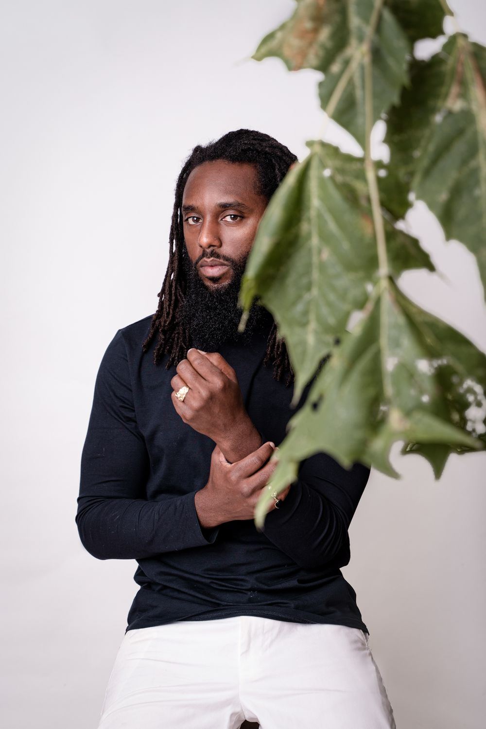 Portrait against white background with green plant leaves as natural elements.