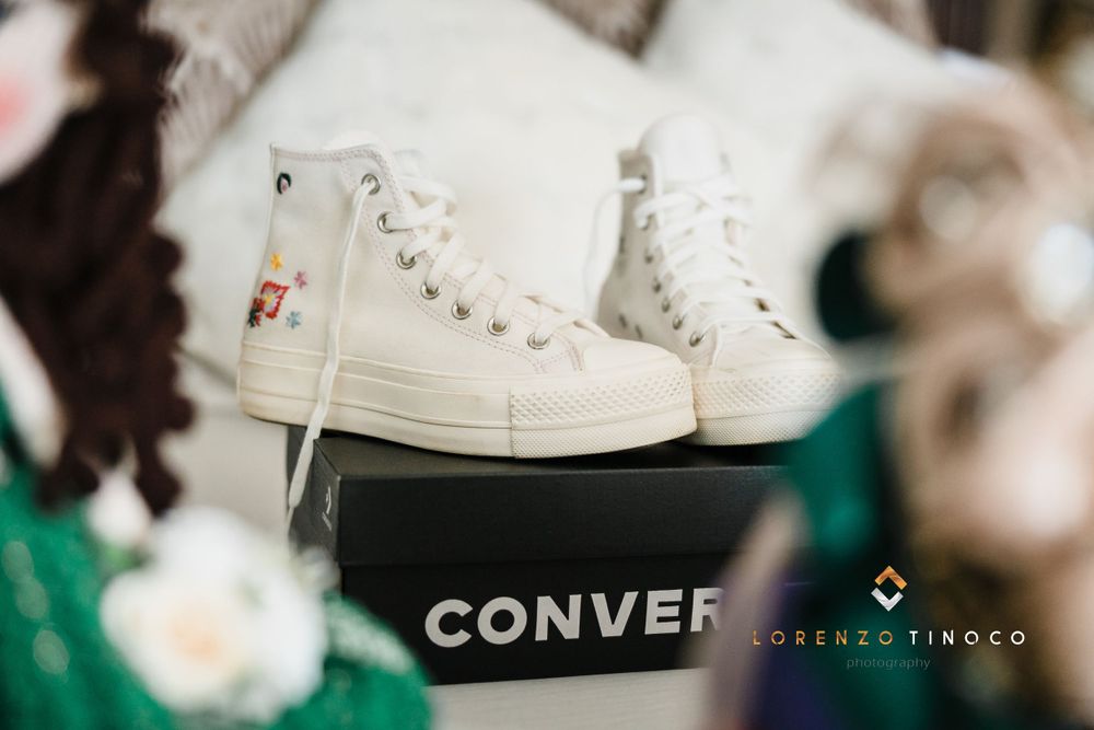 White high-top Converse sneakers displayed on black surface with brand logo visible.