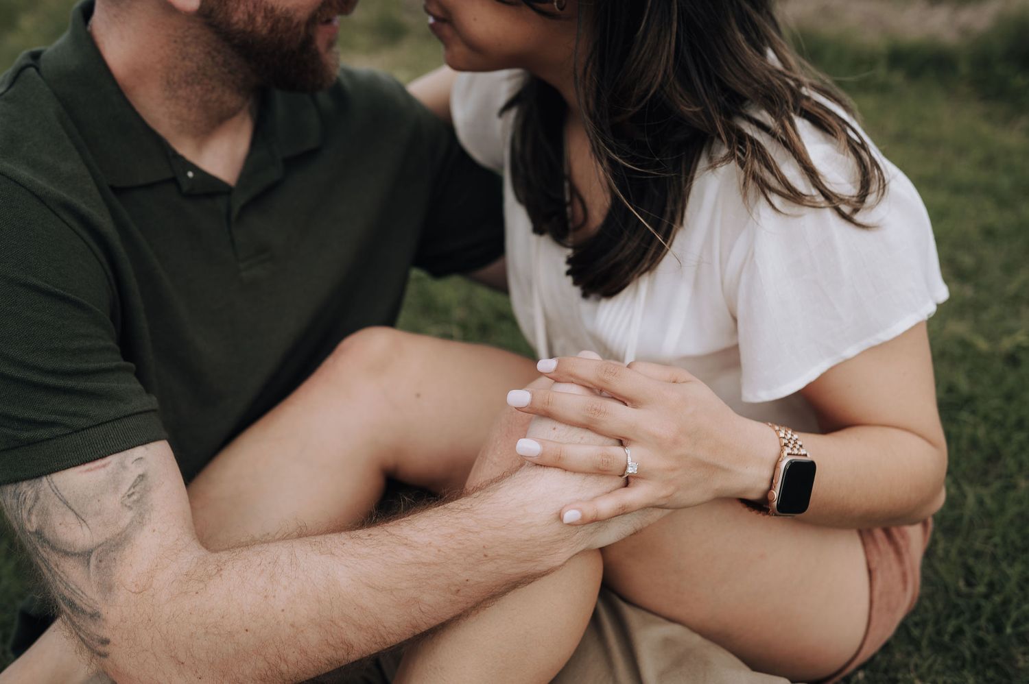 Close up of a couple's hands touching during an intimate outdoor photoshoot.