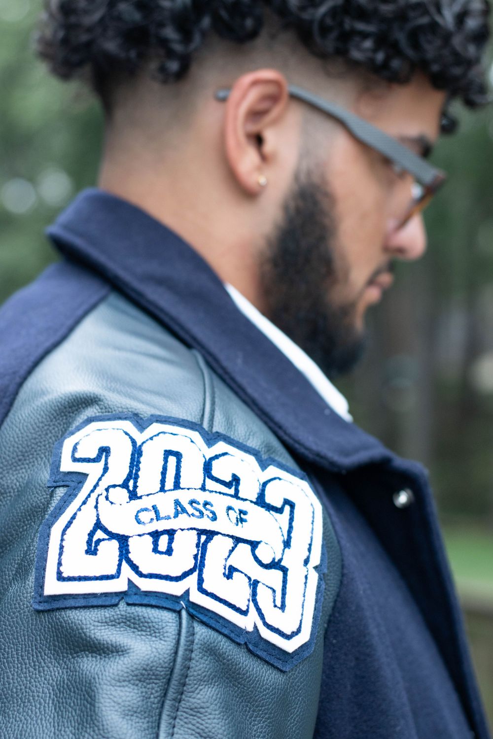 Close-up detail of Class of 2023 lettering on a navy blue varsity jacket.