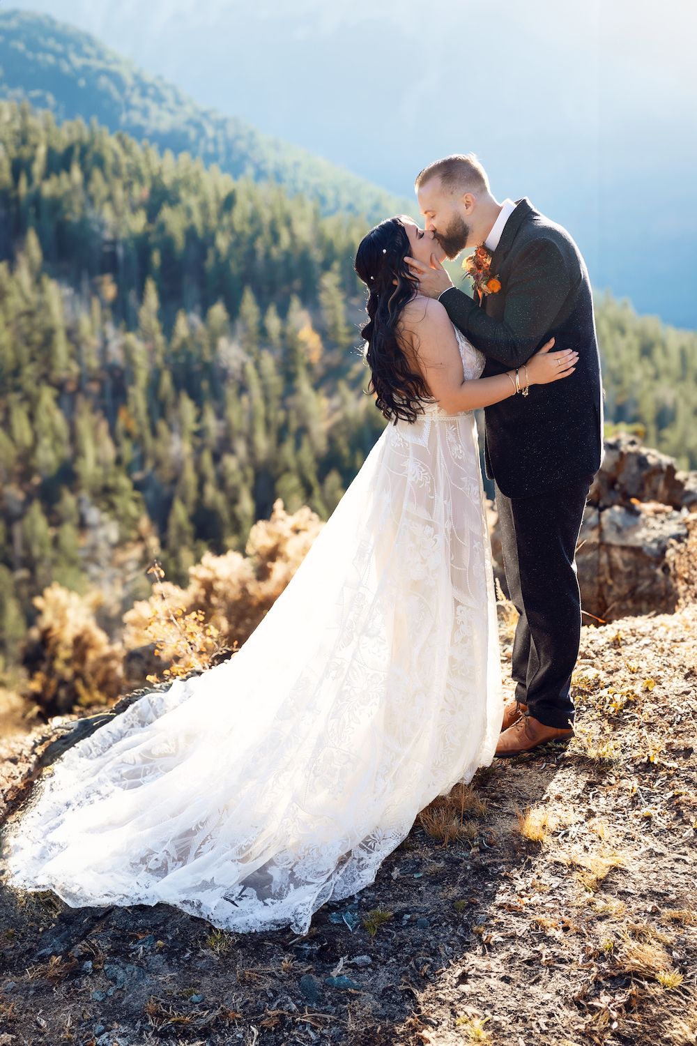 Bride and groom kissing on a mountaintop in Colorado