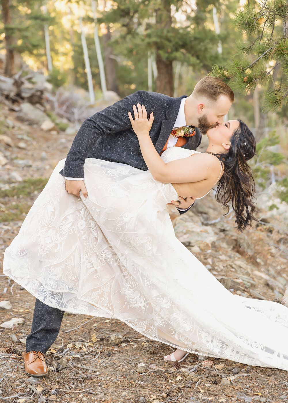 Bride and groom kissing at in a forest in Colorado
