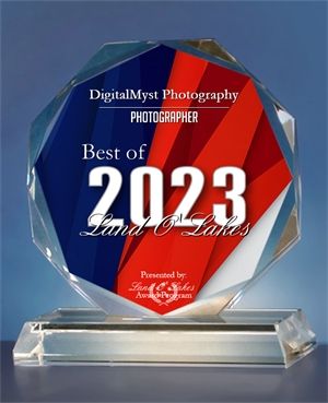 Crystal award plaques displayed showing 2023 photography awards in blue and red design.