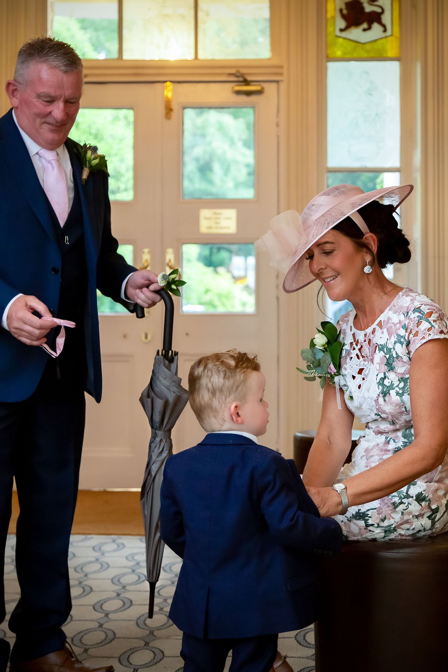 A heartwarming candid moment between three people during a formal occasion in an elegant room.