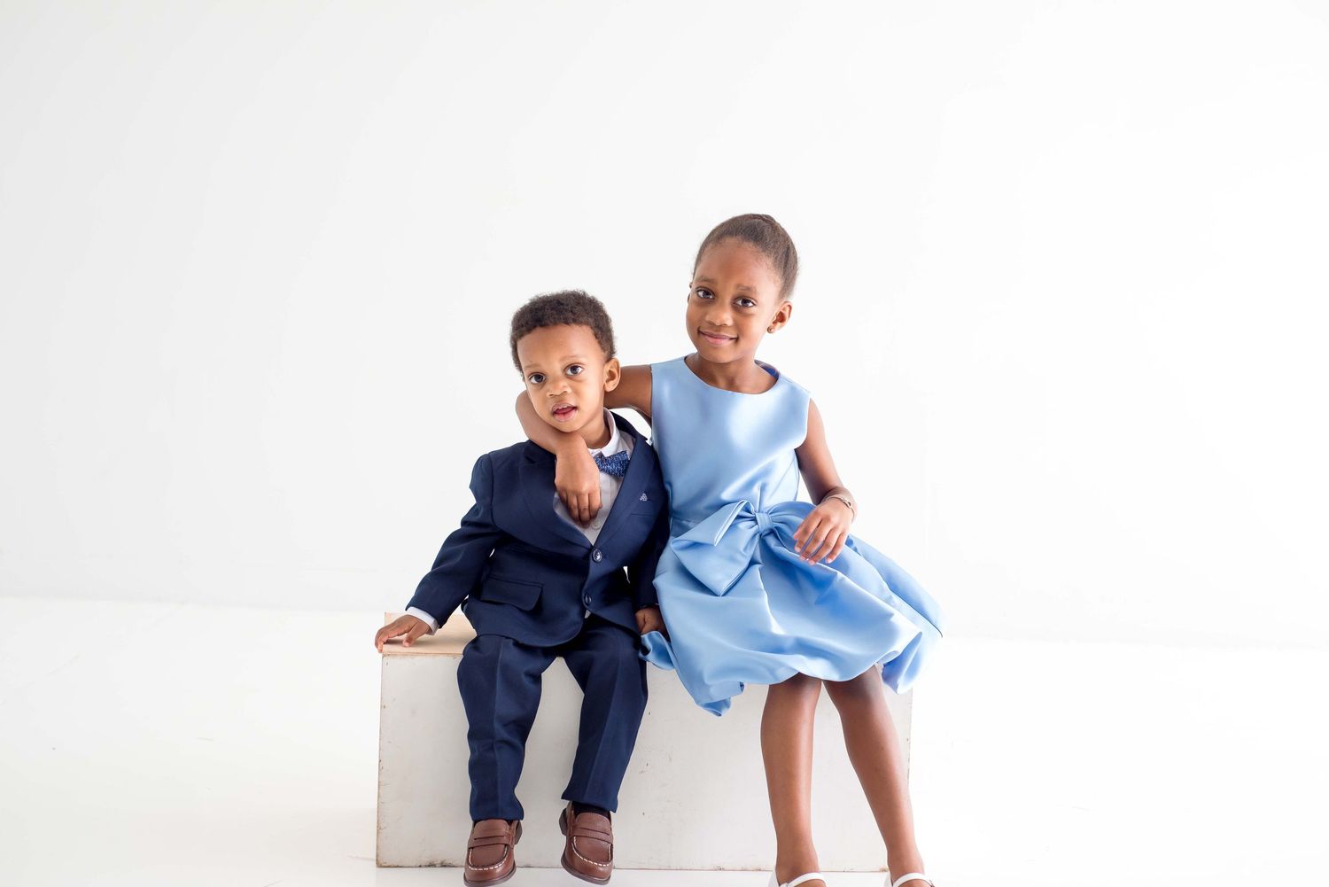 brother and sister taking pictures in a white studio